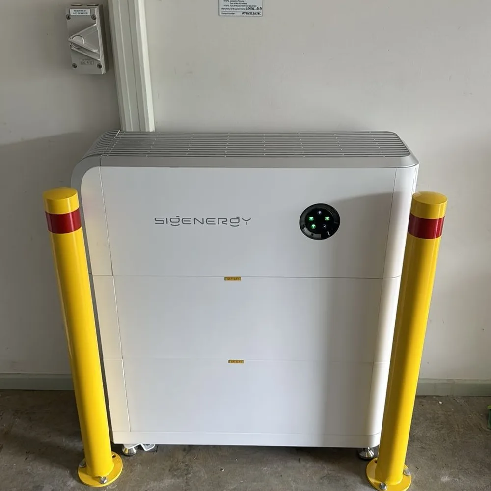 Sigenergy home battery in a garage, protected by two yellow bollards