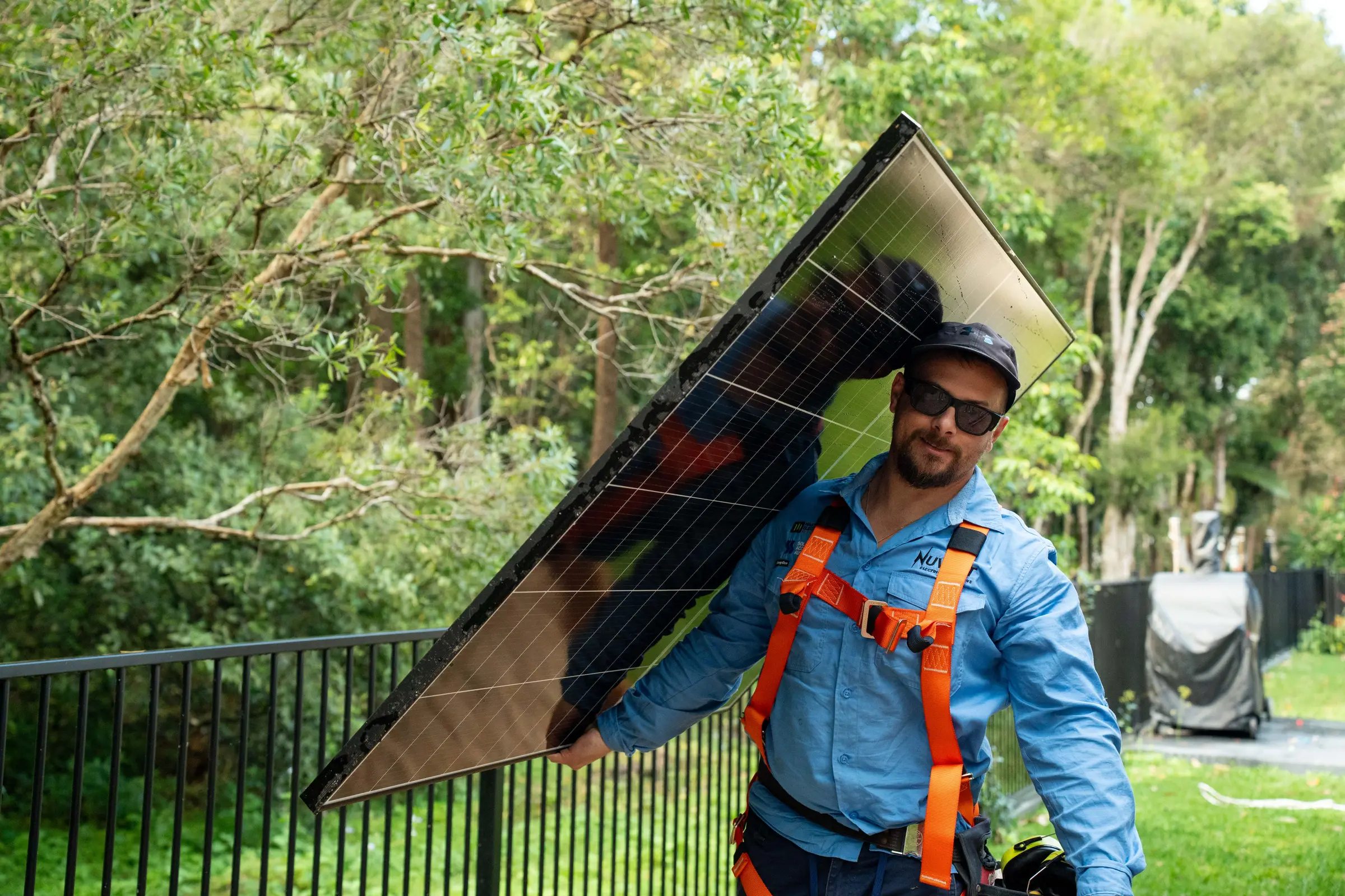 Daniel Carmont, Nuvolt's founder and licensed electrical contractor, carrying a solar panel on his shoulder at a Sunshine Coast install